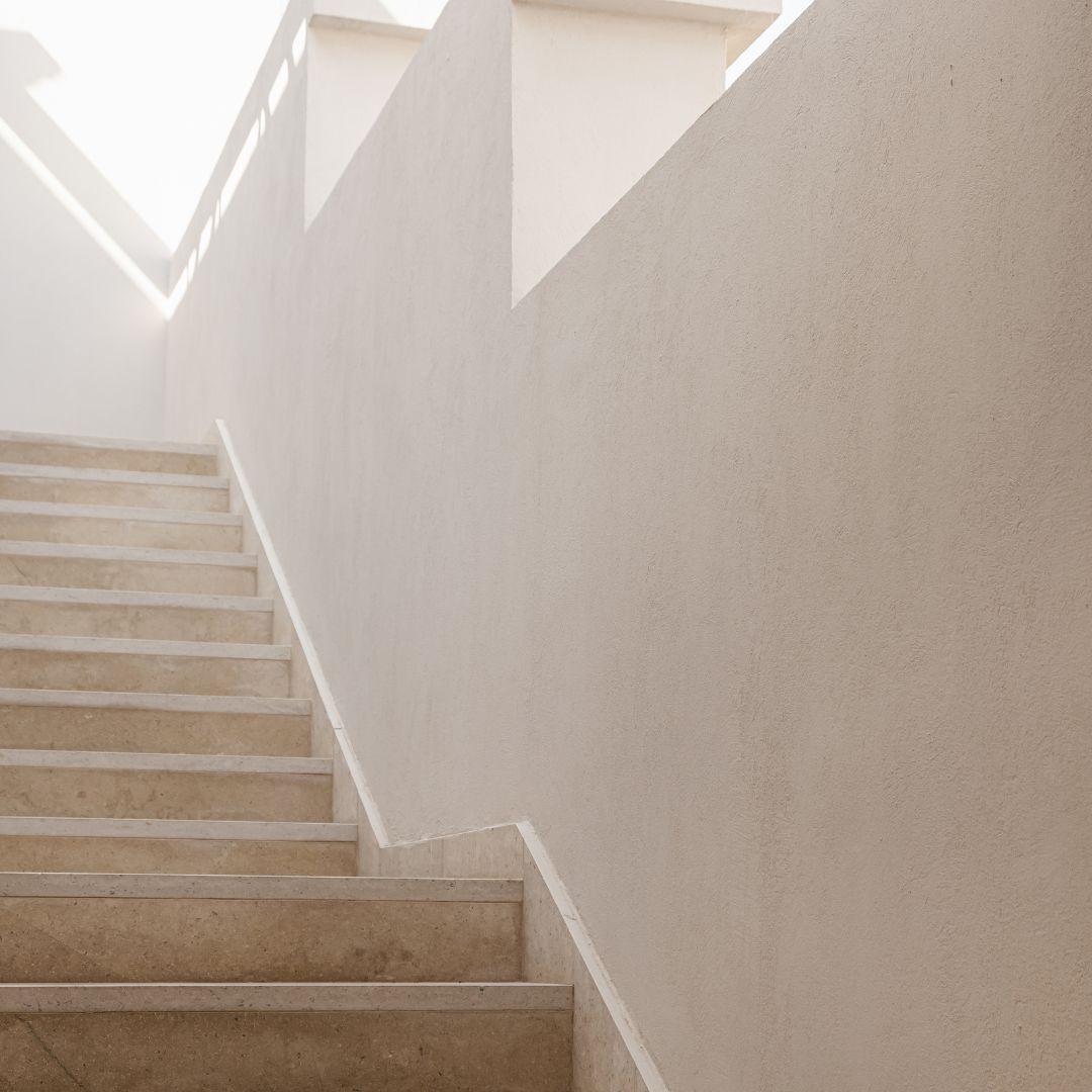 Un escalier clair baigné de lumière, qui monte marche après marche.